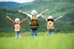 Group family children travel nature trips raise arms and standing see mountain outdoors, adventure and tourism for destination leisure trips for education and relax in nature park. Travel vacations 