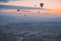 Hot air balloons over Cappadocia area in Turkey. Spectacular view of hot air balloons and Cappadocia in sunrise light.