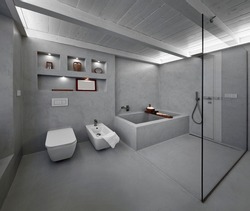  modern bathroom interior covered in grey resin with tub and shower in masonry, a glass wall separates their from the entrance door
separates
