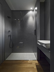 interiors shots of a contemporary bathroom with wooden floor in the bottom the masonry shower glass box with resin walls