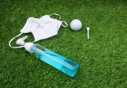 Golfer hand  golf ball with face mask hand gel to preparing for corona virus before go to golf course                    
