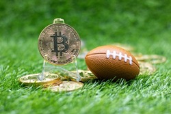 Bitcoin with American Football is on green grass for betting concept