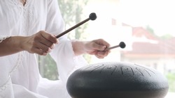 Hands of asian woman musician playing steel tongue drum,music and instrument.
