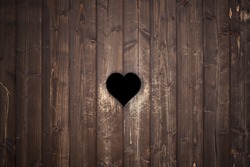 Old weathered wood planks texture with carved heart, love sign  background.