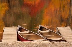 Two boats or canoes sitting in a lake during the peak of autumn in the North Carolina mountains.