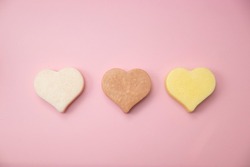 Heart shaped pink bar of soap on a light pink background. Top view, copy space. Heart shaped soaps. Importance of personal hygiene care. Copy space