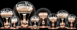 Photo of light bulbs with shining fibers in a shape of CONSULTING concept related words isolated on black background
