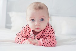 Cute baby on the white bed