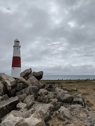 Lighthouse to the side of the edge of England by the coast on a moody and dark day 