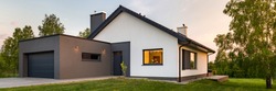 Panorama of a stylish house with large lawn and garage, outdoors