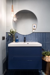 Designed bathroom with stylish blue cabinet and blue wall tiles