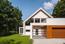 Modern designed white house with big garden and garage, exterior view