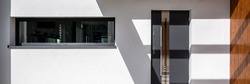 Panorama of simple front doors and long window in white facade house, exterior view