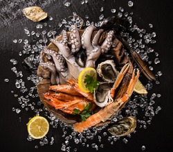 Fresh seafood on black stone, close-up.