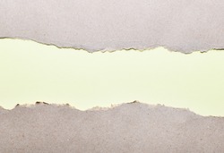 Dark paper with torn edges on a light green background of colored paper inside. Good paper texture