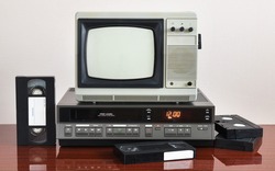 Old silver vintage TV with VCR on wallpaper background.