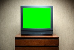 Vintage Television on wooden antique closet, old design in a home.Old black vintage TV with green screen to add new images to the screen.