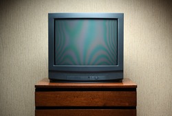 Vintage TV on wooden antique closet, old design in a home.Old black vintage TV.
