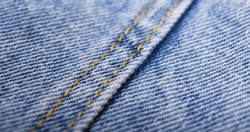 Old blue jeans background and texture close up.Denim seam. 