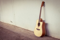 acoustic guitar on gray wall background with shadow edge.vintage tone.