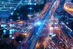 FOREX and stock market chart hologram on aerial view of road, busy urban traffic highway at night. Junction network of transportation infrastructure. The concept of international trading.