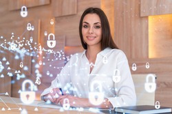 Portrait of attractive businesswoman working with documents and thinking how to protect clients confidential information and cyber security. IT hologram padlock icons over office background.