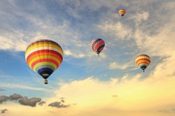 Colorful balloons rising up during sunset