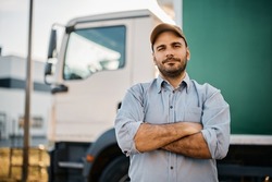 Portrait of confident truck driver on parking lot looking at camera. Copy space.