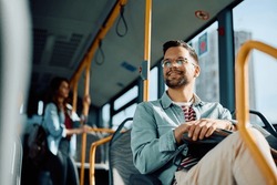 Low angle view of happy man riding in a bus. Copy space. 