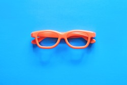 Flat lay fashion set: sunglasses on pastel backgrounds. Fashion summer is coming concept. Orange glasses on a blue background, top view. Trendy minimal style with colorful paper backdrop.