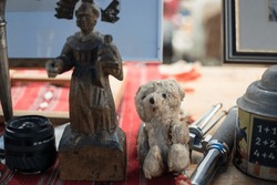Old abandoned teddy bear toy and antique statuette in in an open-air flea market in Vienna Austria