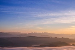 Sea of mist scenary at sunrise time. Beautiful blue sky with cloud. Silhouette mountains.