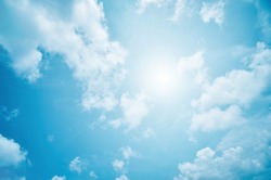 abstract light blue background, soft clouds and sky with sun rays