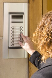 Woman  calling on the intercom and presses the button