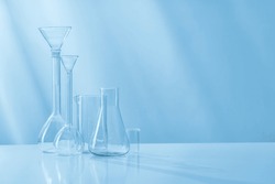 Glass test tubes, various dishes of a chemical laboratory on a light background.