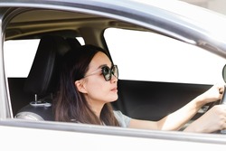 Happy asian woman driving a eco hybrid car.Happy woman is driving a car service.Portrait female driver steering car with safety belt.Electric vehicle.used car rental.Learning to drive.vacation travel.