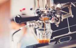 Close-up of espresso pouring from coffee machine.Professional coffee brewing.Barista make coffee latte art with espresso machine in cafe vintage color tone.Espresso speed bar shot.beverage food cafe.