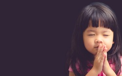 Little girl praying in the morning.Little asian girl hand praying,Hands folded in prayer concept for faith,spirituality and religion.Black 