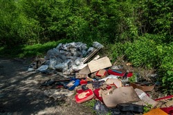 Unauthorized garbage dump near the road in a natural park area. Industrial waste. Garbage dump. Ecological catastrophy. Environmental protection. Nature and people.