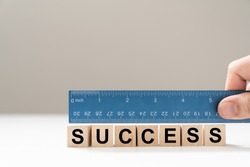 Measure success word using blue ruler, representing a review, evaluation or assessment of an employee