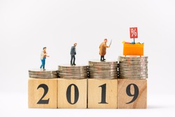 Miniature people : Close up of miniature shopper and display shelf figure on coins stacks on 2019 wood block. Festive, holiday, year end discount,and boxing day.