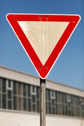 Triangular yield traffic sign outside an urban building