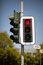 Set of urban robots mounted on a pole with the red traffic light illuminated bringing cars to a halt