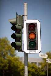 Amber traffic light warning of a progression to a red light bringing trafic to a halt at an intersection