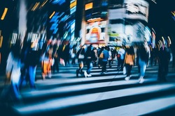 Abstract Radial Blur of pedestrian crossing or crosswalk in Shinjuku City during evening rush hour with many people waiting to cross. Urban nightlife and commuter rushing concept in Tokyo, Japan.