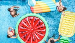Happy friends playing with air lilo ball inside swimming pool - Young people having fun on summer holidays vacation - Travel, holidays, youth lifestyle, friendship and tropical concept