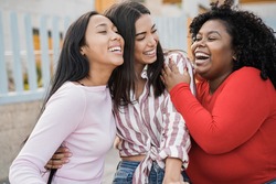 Happy latin girls enjoy time together outdoor around city - Friendship and diverse ethnicity concept - Main focus on black woman face