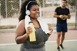 Curvy woman doing workout morning routine outdoor at city park - Focus on face
