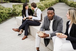 Multiethnic business people doing lunch break outdoor from office building - 