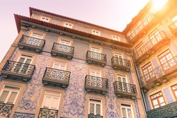 Facades of typical old town houses in Portugal - Colonial building concept - Vintage editing with artificial sunlight